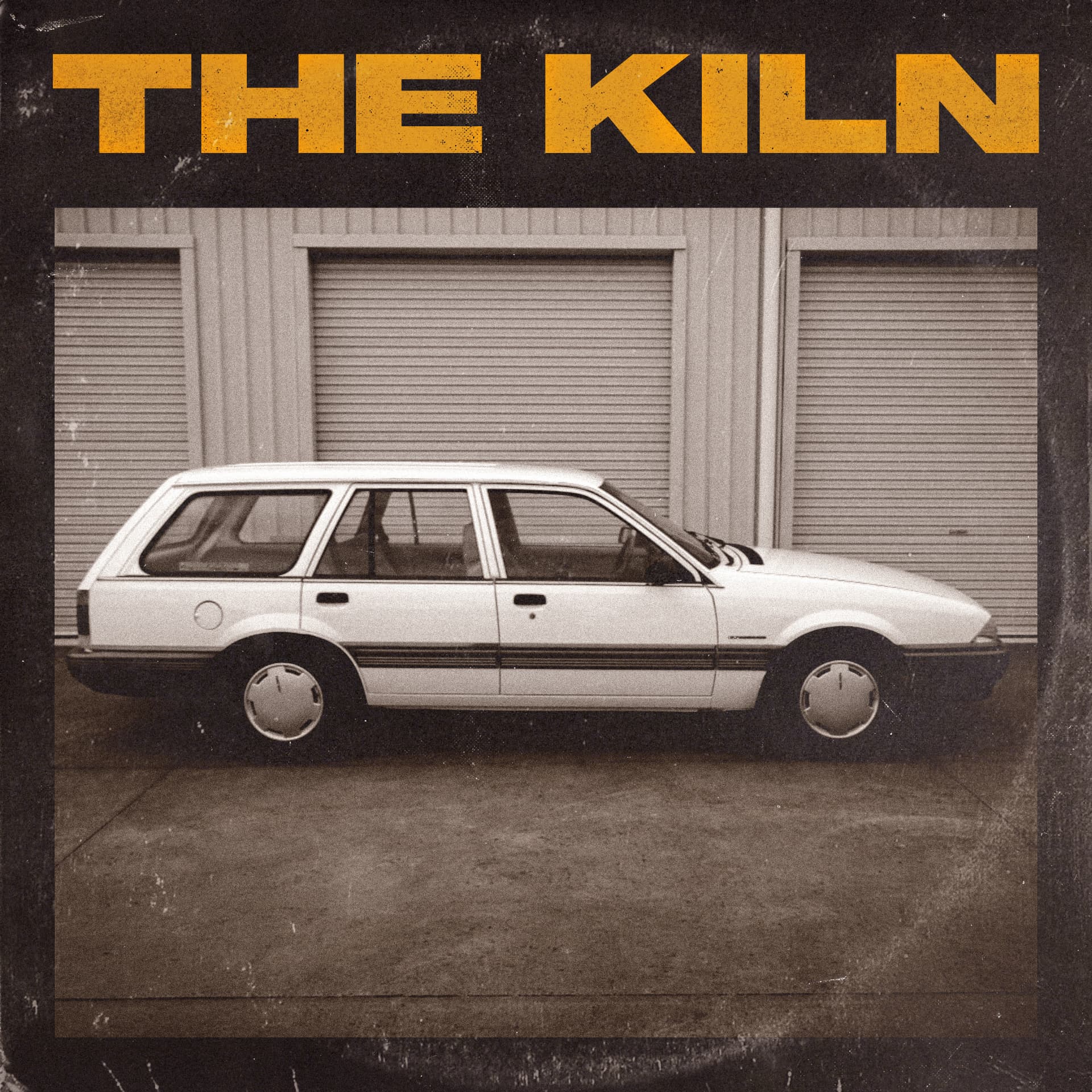 The Kiln debut album cover — a white station wagon parked in front of roller doors